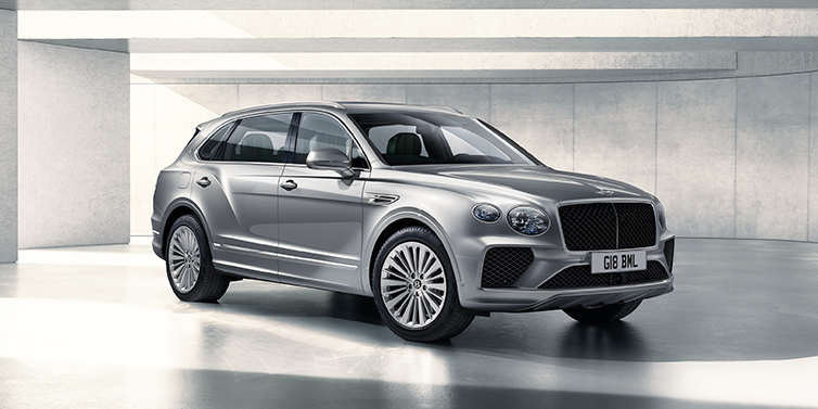 Bentley Antwerp Bentley Bentayga Extended Wheelbase SUV front three quarter in Moonbeam paint with a grey background